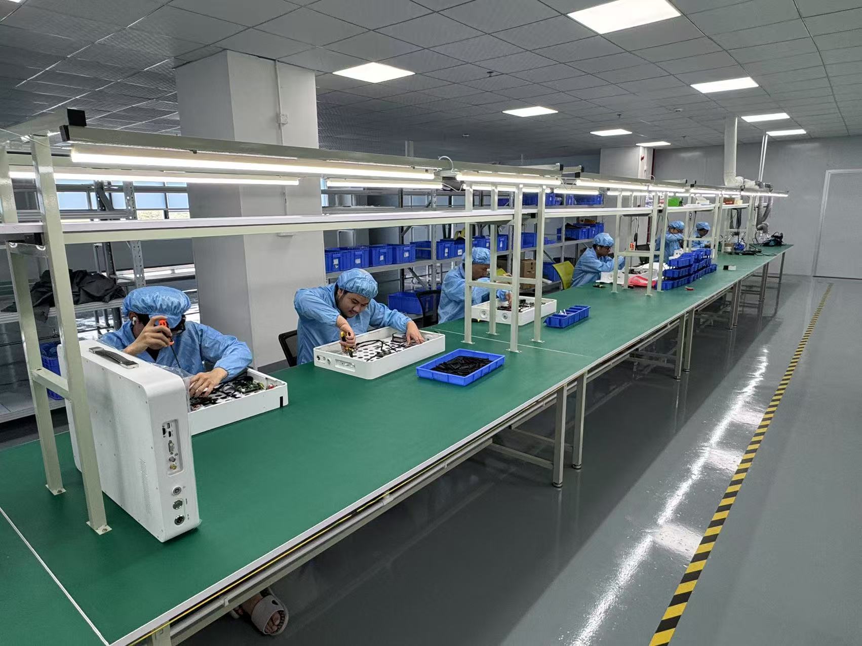 Technicians assembling electronic devices at the production workbenches