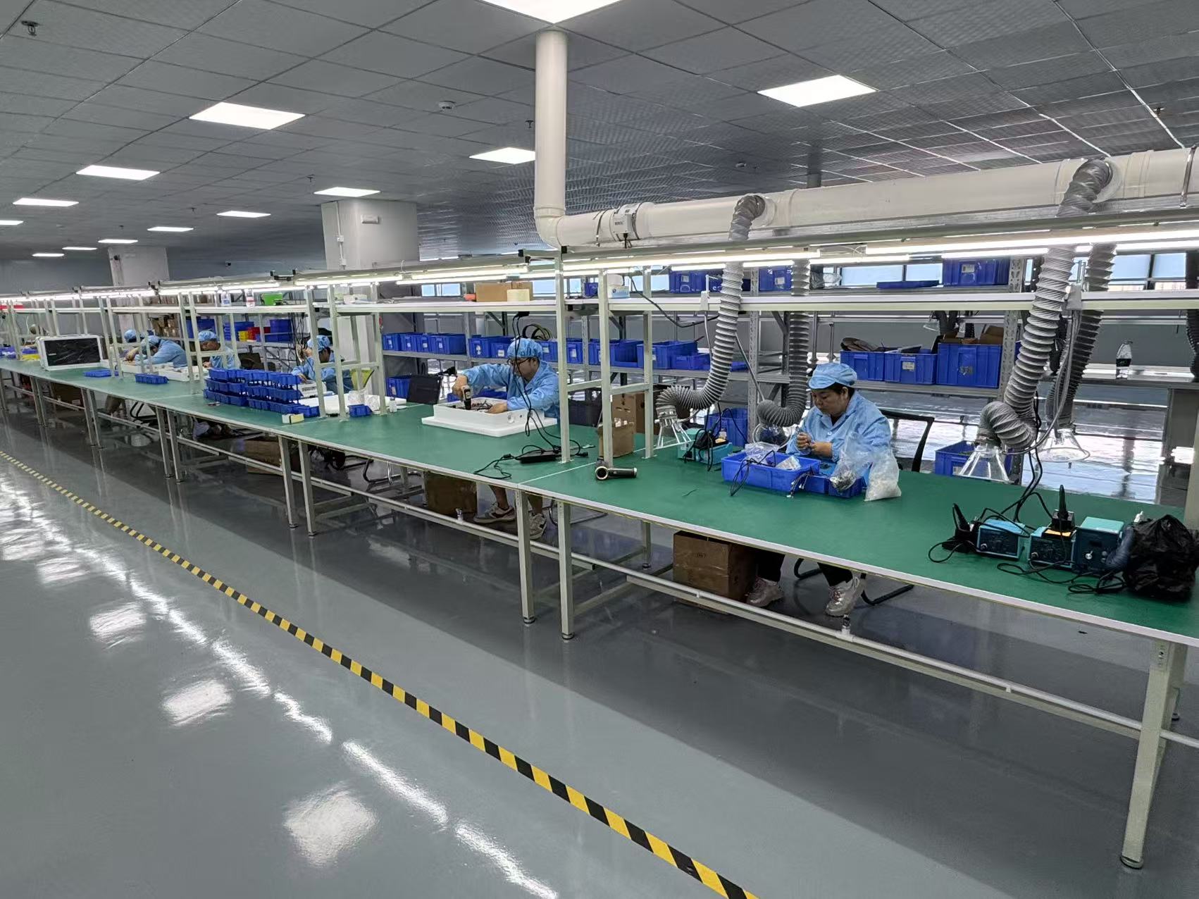 Electronics production line with assembly stations and extraction equipment